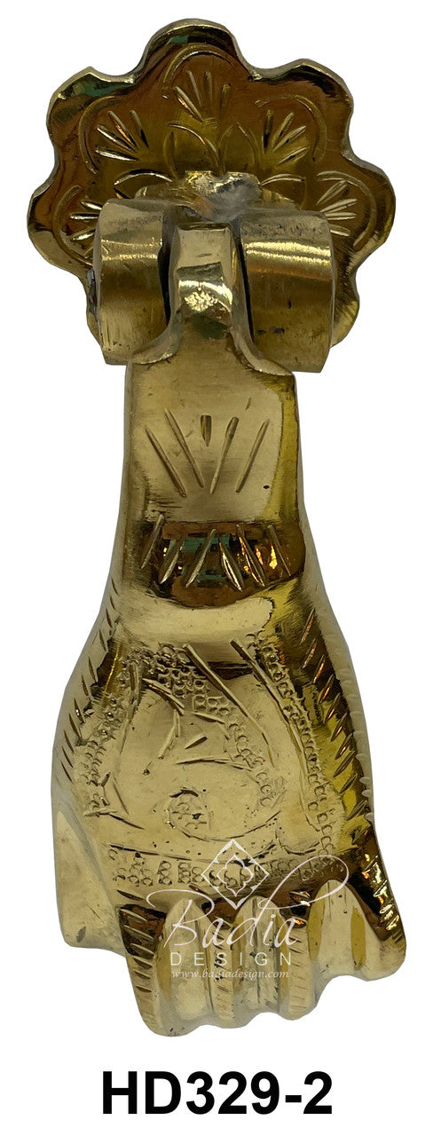 Decorative brass door knocker with intricate design on a white background