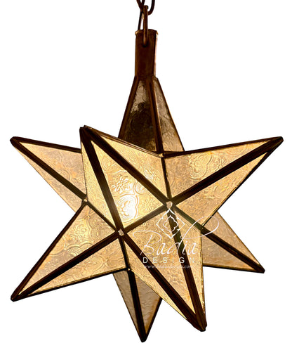 A hanging six-pointed star pendant light made of textured gold-toned metal panels with dark bronze or black metal framing, shown against a plain white background.