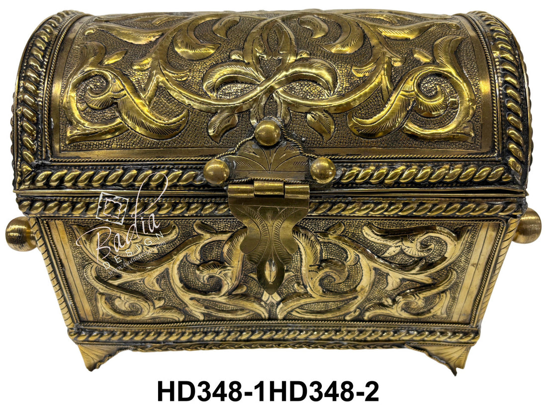 Decorative brass box with intricate patterns on a white background