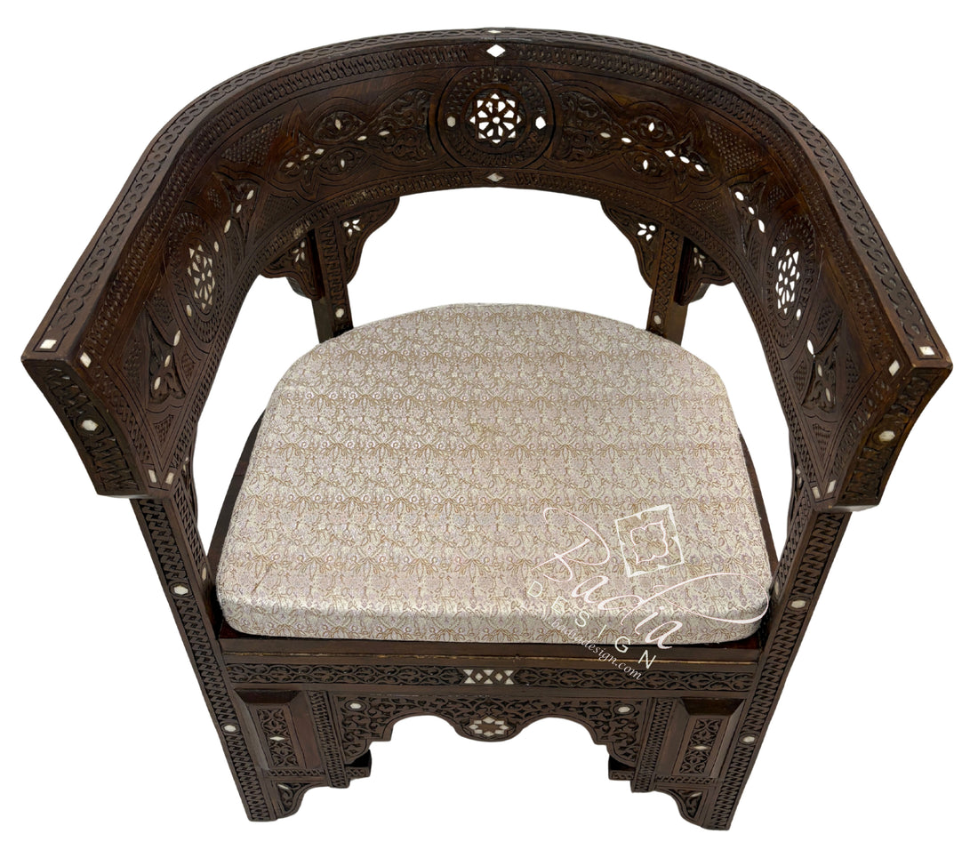 Decorative wooden chair with intricate carvings and a patterned cushion on a white background.