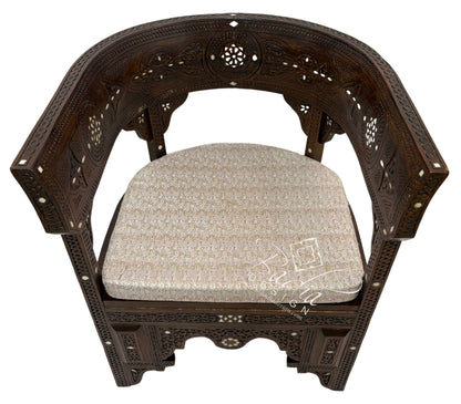 Decorative wooden chair with intricate carvings and a patterned cushion on a white background.