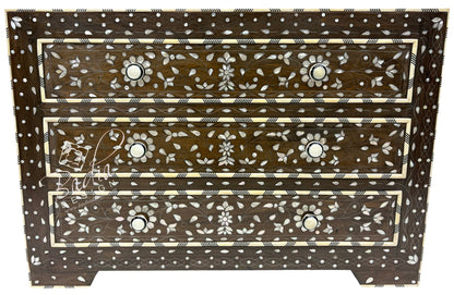 Wooden chest of drawers with intricate bone inlay patterns on a white background