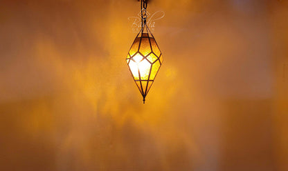 Decorative hanging lamp with a warm glow against a blurred background