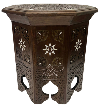 Decorative wooden side table with intricate carvings on a white background