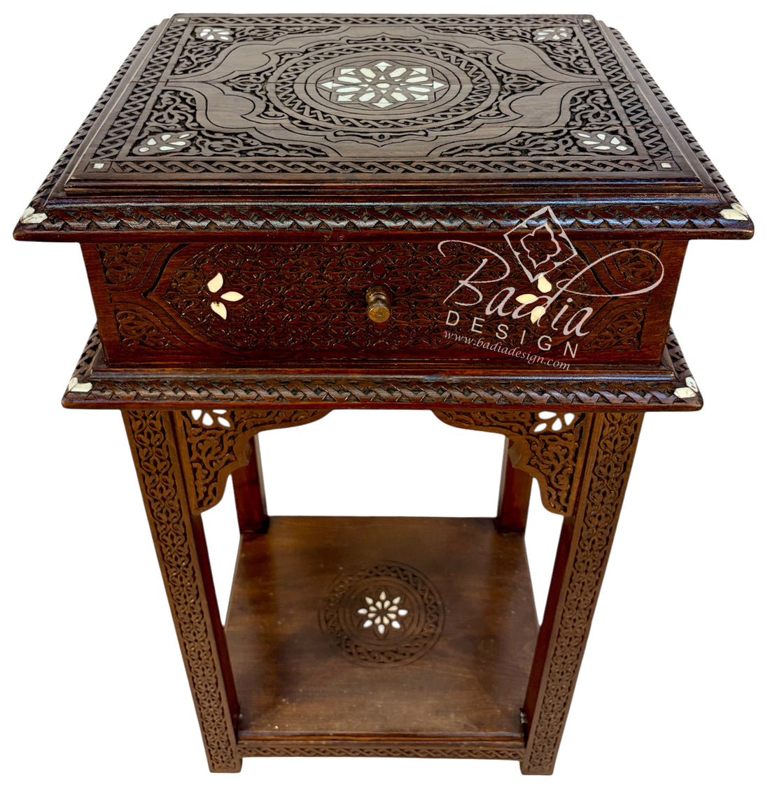 An ornate dark brown carved wooden console with a single drawer, intricate inlay details, and a lower shelf, shown on a plain white background.