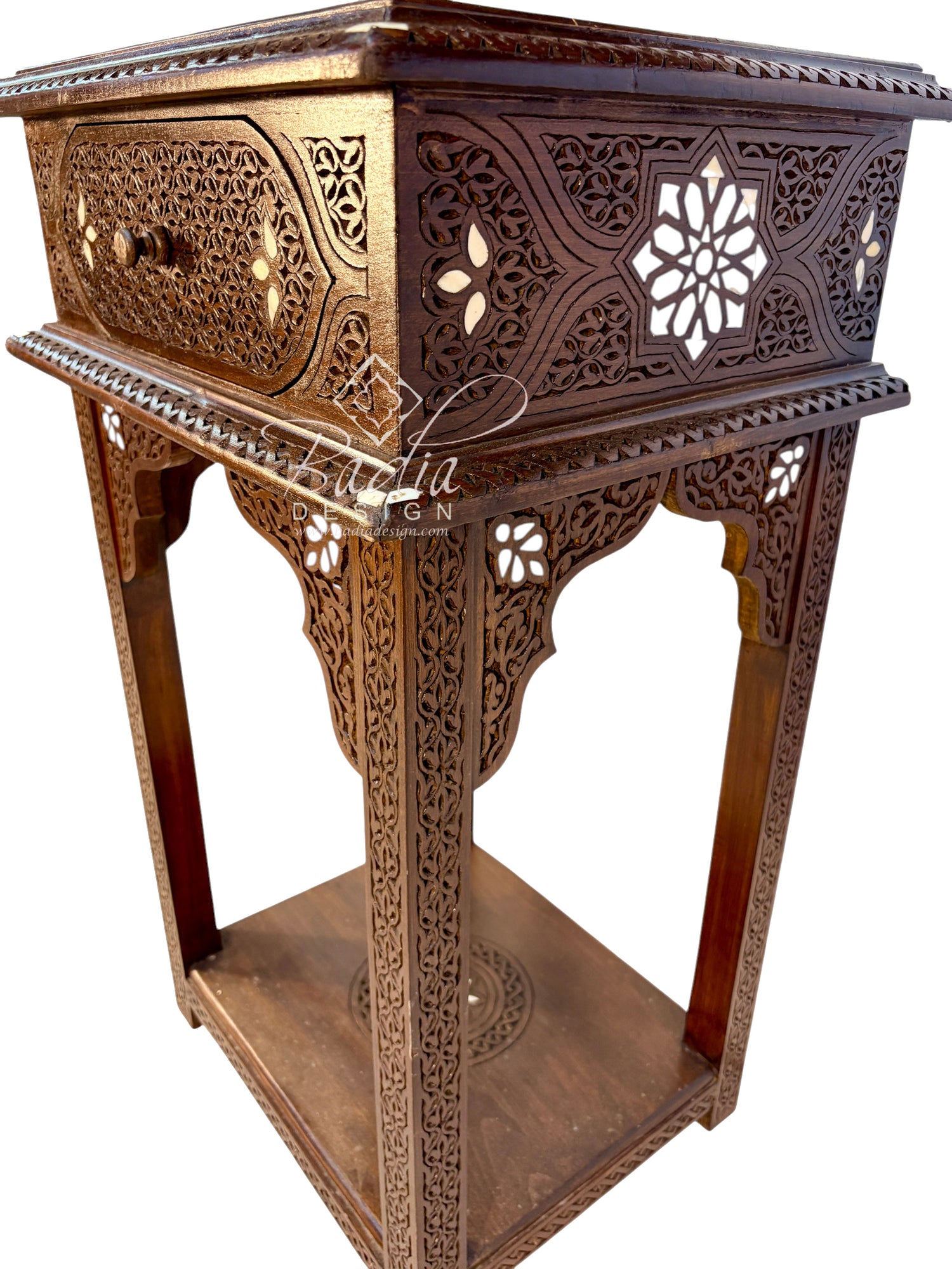 An ornate carved wooden stand or side table with intricate geometric cutouts, a single drawer, and a lower shelf, shown on a plain white background.