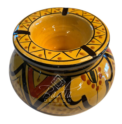 A hand-painted ceramic pot with a wide rim, featuring a yellow and black geometric pattern with red accents, shown on a white background with a &