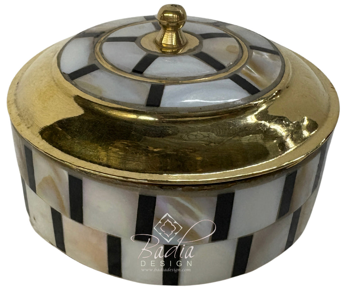 Decorative container with gold lid and black and white striped pattern, featuring Badia Design logo.
