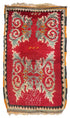 A rectangular vintage-style rug with a deep red field, ornate cream and light blue scroll motifs, and a dark border with orange and beige accents.