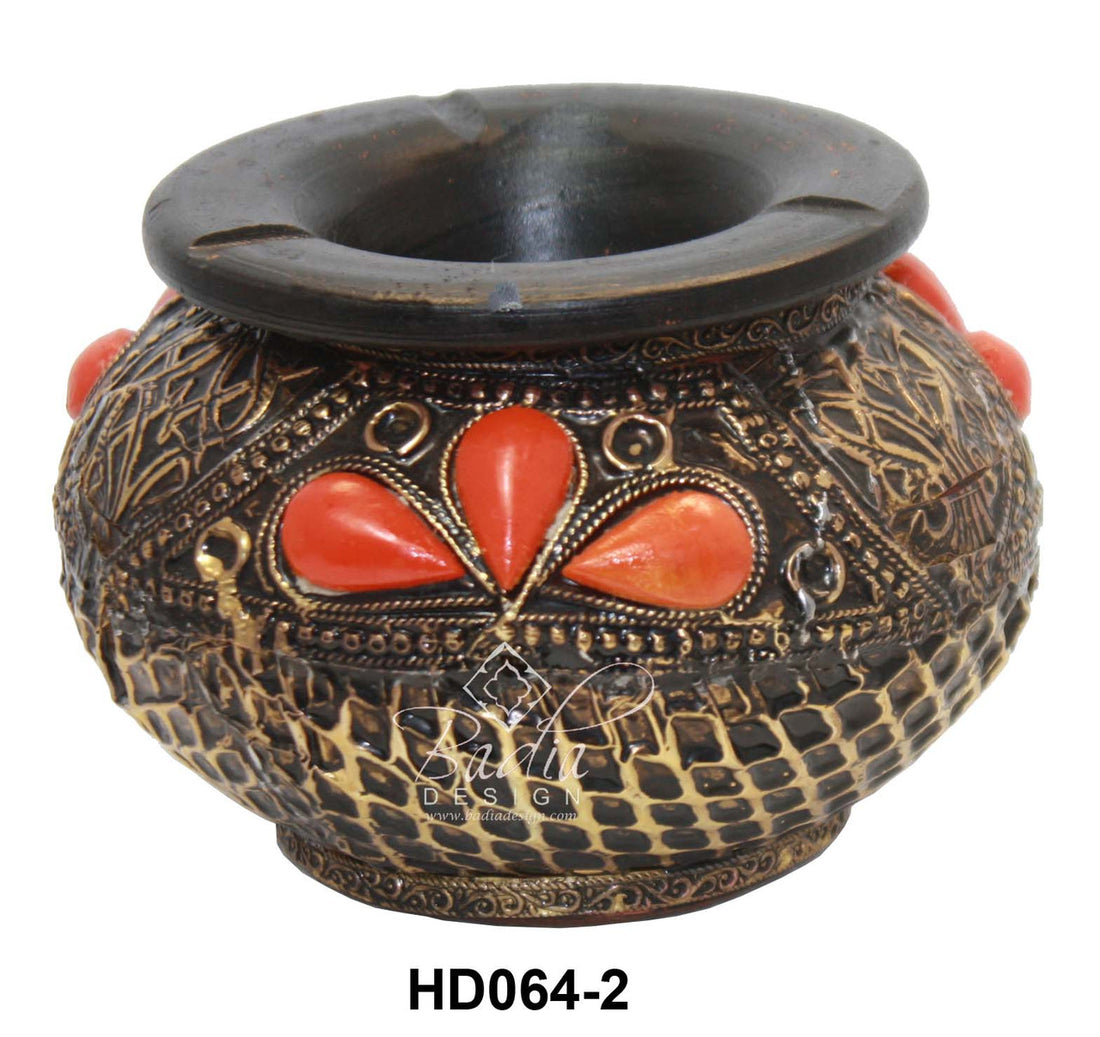 Decorative pot with intricate patterns and red stones on a white background