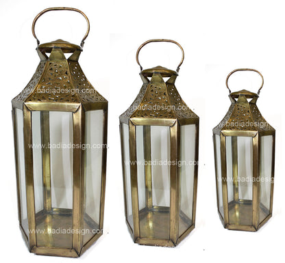 Three brass lanterns of different sizes on a white background with &