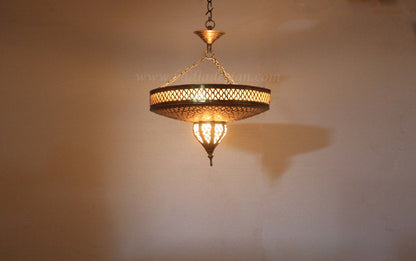 Gold chandelier casting a shadow on a beige wall
