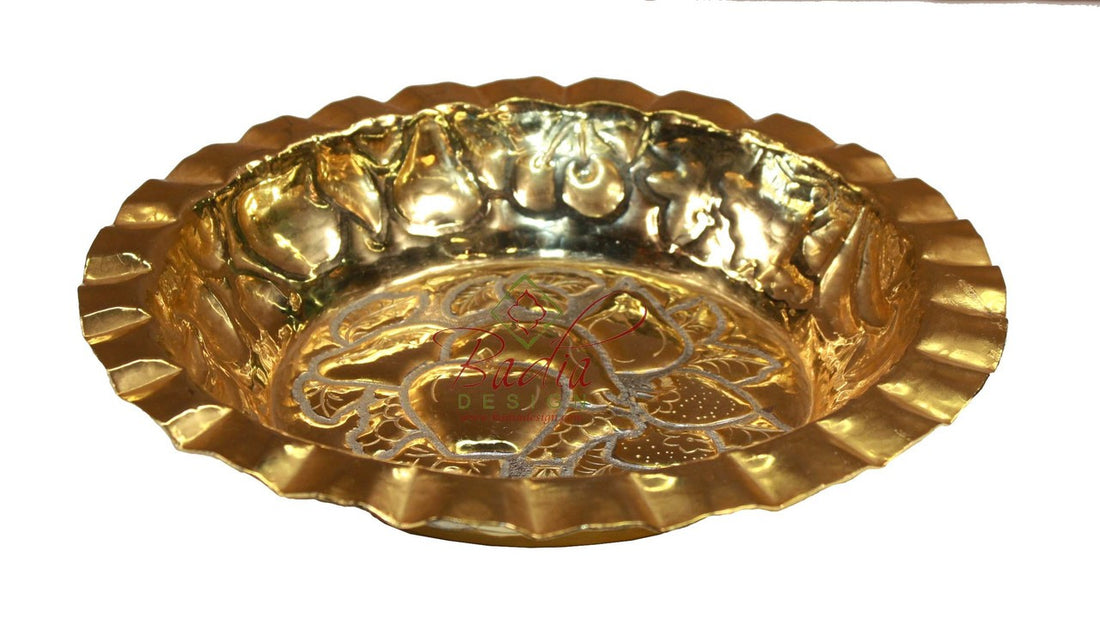 Gold decorative plate with embossed design on a white background