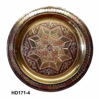 Decorative metal plate with intricate designs on a white background