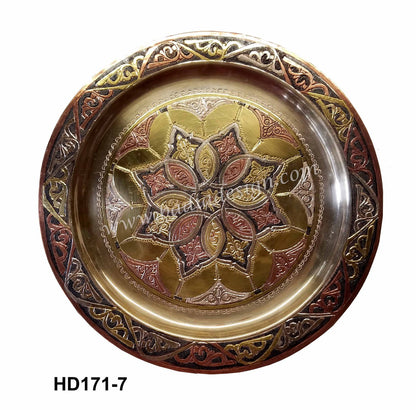 Decorative metal plate with intricate designs on a white background