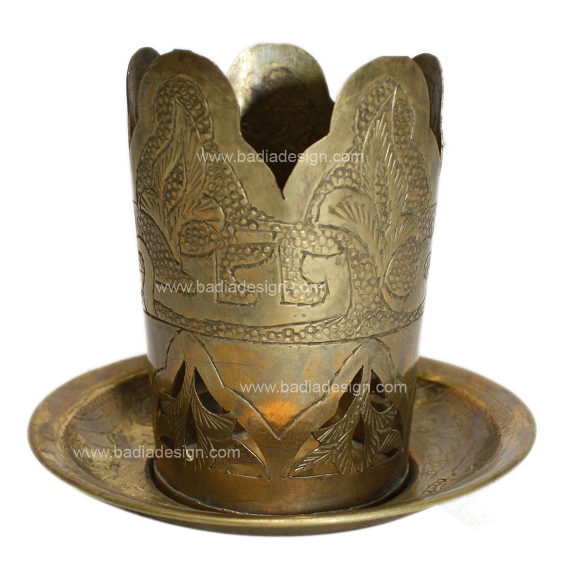 Decorative brass candle holder with intricate designs on a white background