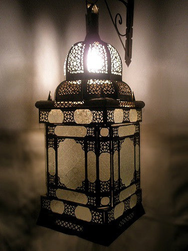Decorative hanging lantern with intricate patterns on a dark background
