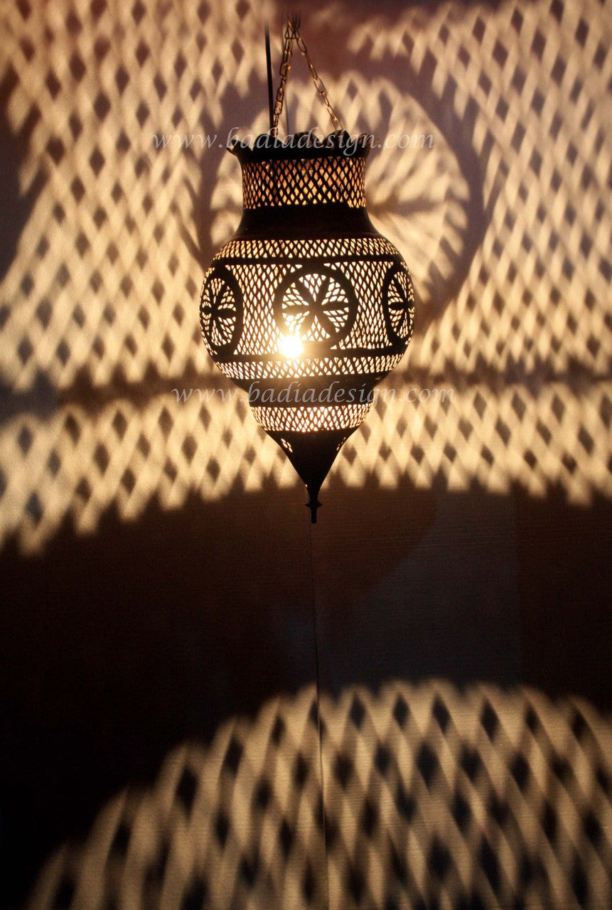 Decorative hanging lamp casting shadows on a textured wall