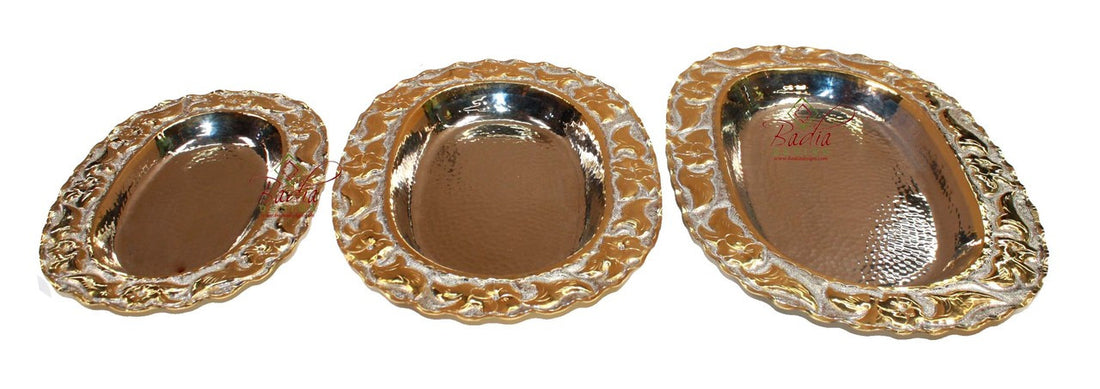 Three ornate metal trays with decorative borders on a white background