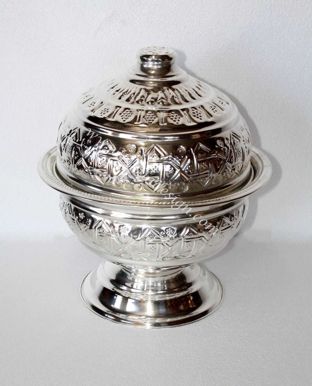 Silver decorative container with intricate patterns on a white background
