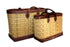 Two woven baskets with brown leather trim on a white background