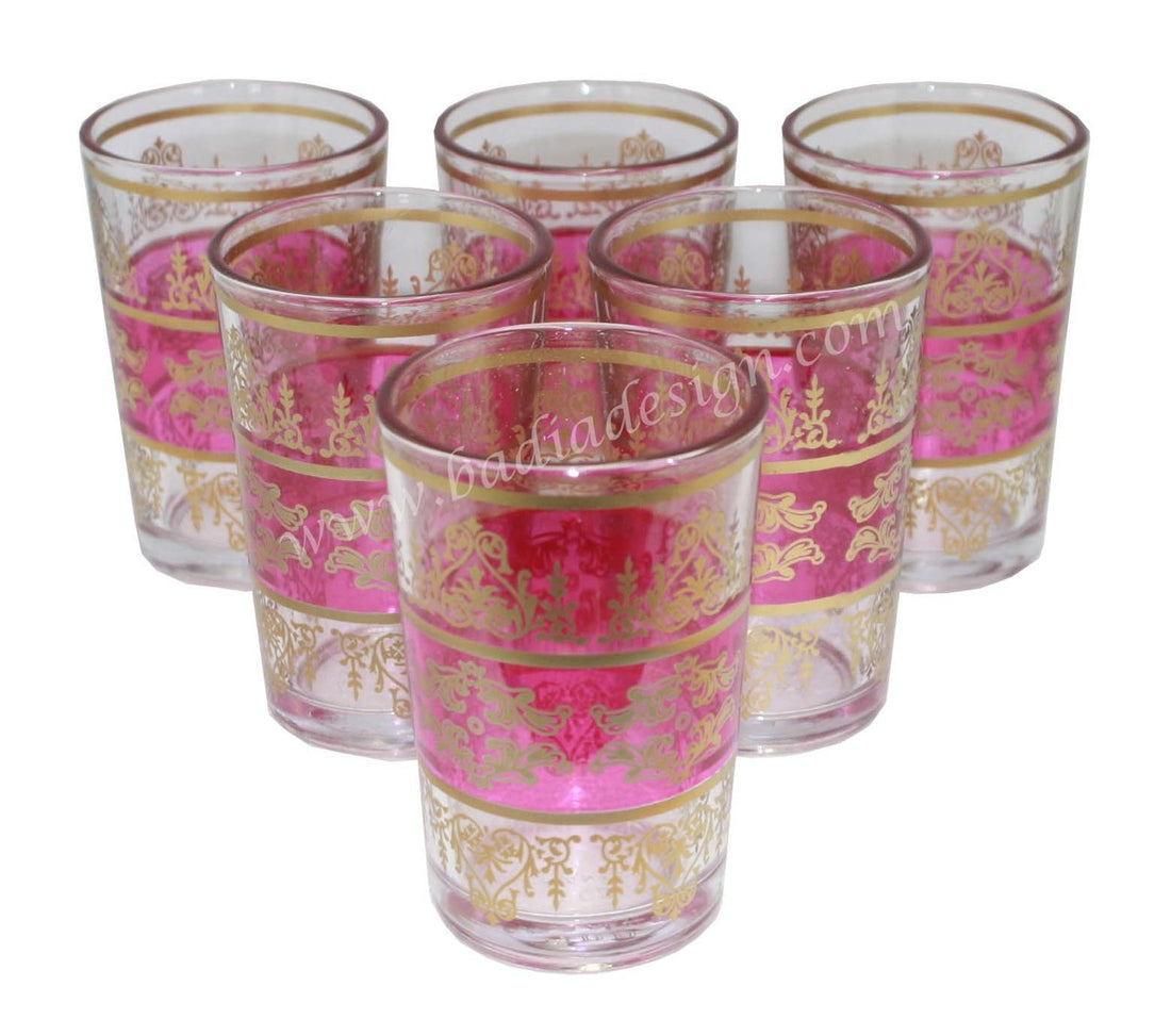 Set of six tea glasses with pink and gold decorative patterns on a white background.