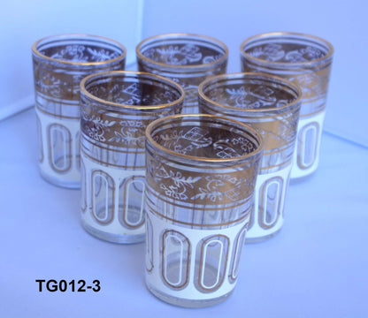 Set of six glasses with gold patterns on a white surface