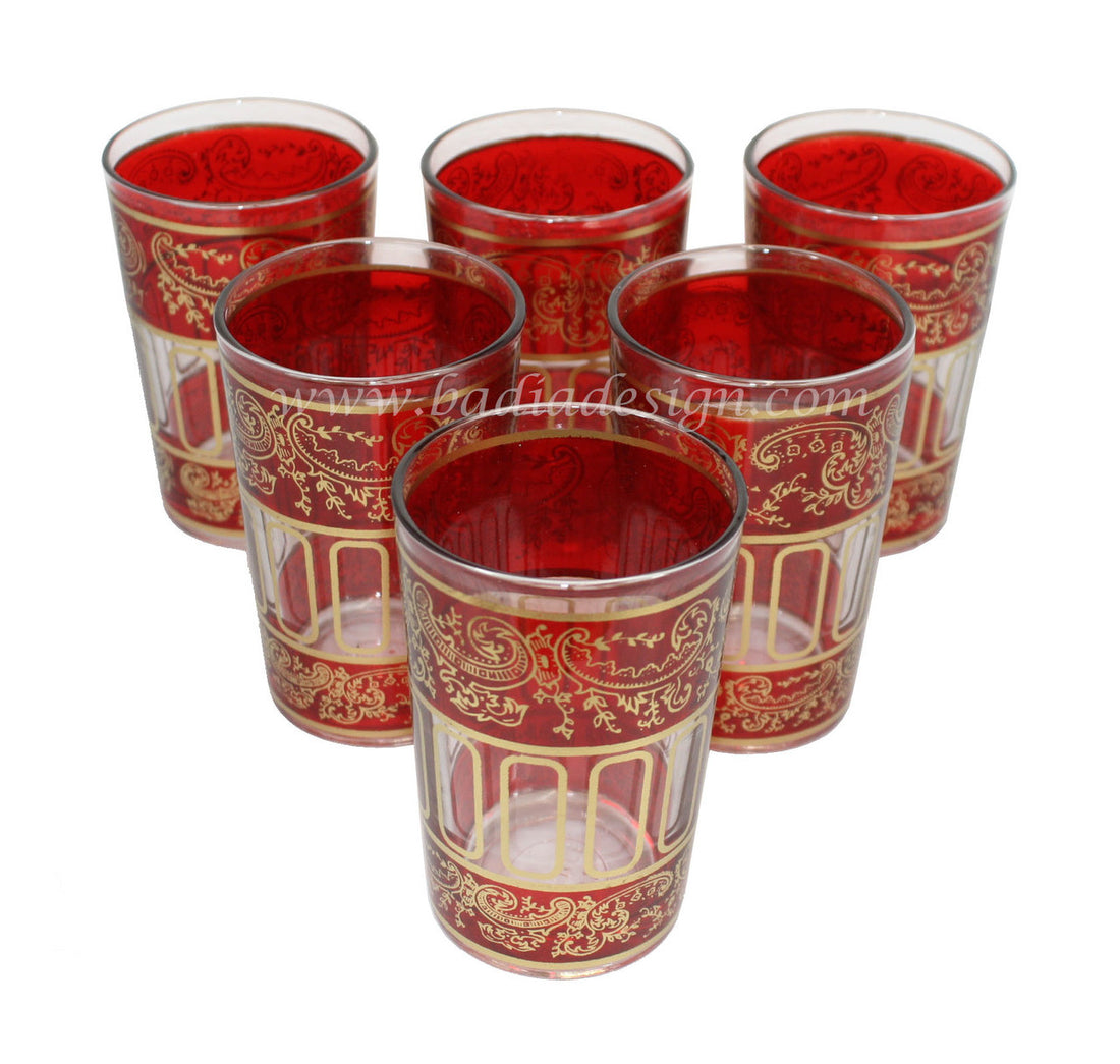 Set of six red glass tea cups with gold patterns on a white background