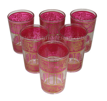 Set of six pink glass tea cups with gold patterns on a white background