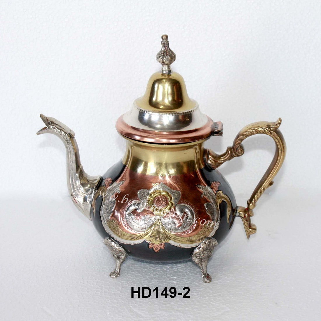 Decorative teapot with intricate designs on a white background