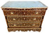 An ornate three-drawer wooden chest of drawers with intricate mother-of-pearl inlay work in brown, gold, and cream, topped with a light blue-gray marble slab, shown on a white background.