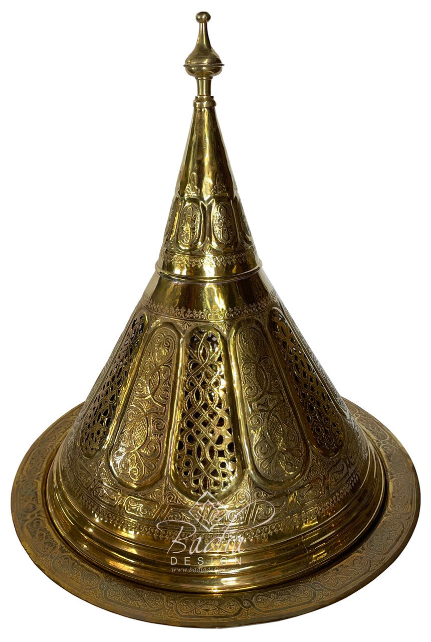 Decorative brass cone-shaped object with intricate designs on a white background
