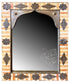 An ornate rectangular wall mirror with a decorative frame made of light wood and dark metal accents. The frame features intricate carved and embossed geometric patterns around the border and a scalloped metal top section.