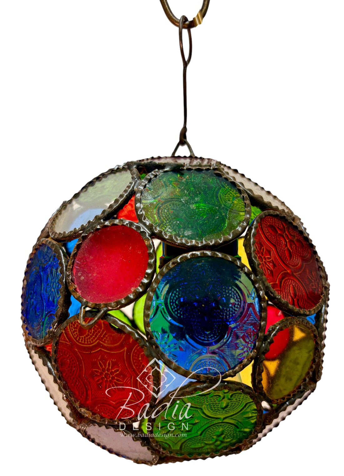 A spherical stained glass ornament featuring a mosaic of colorful glass panels in red, blue, green, yellow, and purple, framed by a distressed silver-tone metal border and suspended by a metal ring against a white background.
