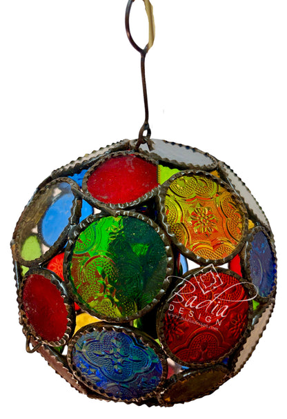 A spherical stained glass ornament featuring multiple colorful glass panels in red, green, blue, yellow, and orange, framed in a silver-toned metal mesh with decorative borders, suspended by a metal ring against a white background.