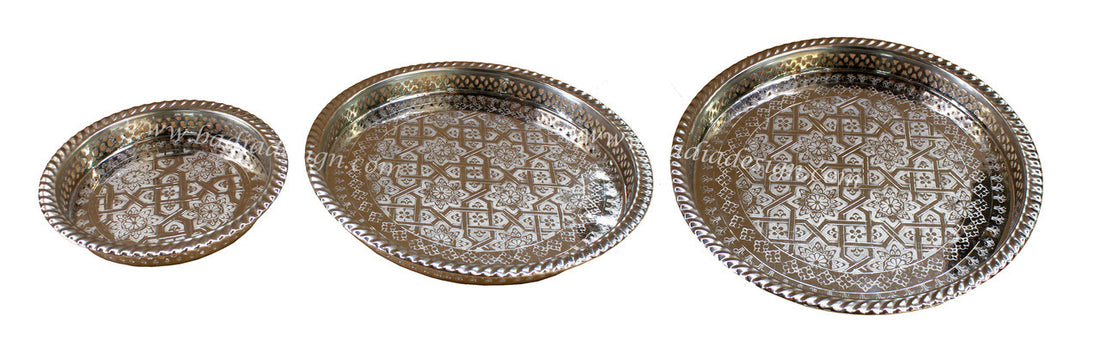 Three silver trays with intricate patterns on a white background