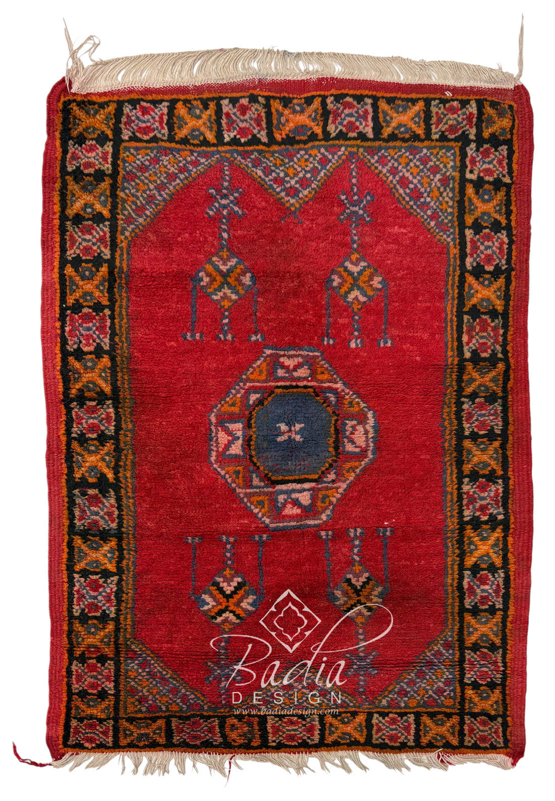 A red hand-woven area rug with a central octagonal medallion, geometric borders, and cream fringe on the top and bottom.