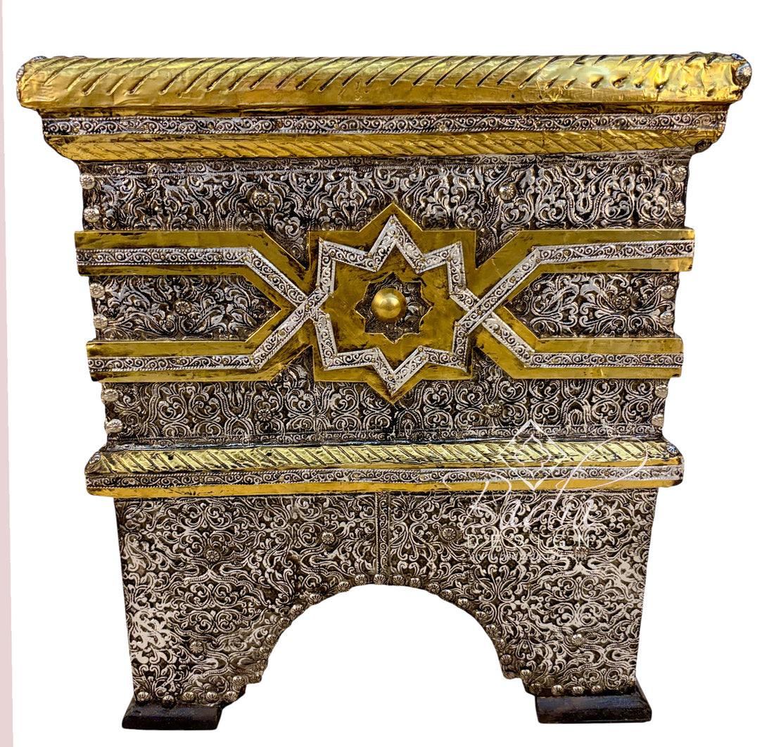An ornate rectangular decorative chest or cabinet with intricate silver filigree carvings and gold accents, featuring a star motif on the front and a rope-textured top edge, shown against a plain white background.