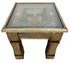 An ornate square side table with a carved brass or bronze metal frame, featuring a clear glass top and intricate floral inlay patterns in gold, silver, and red on the tabletop.