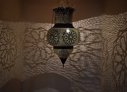 Decorative hanging lantern casting shadows on a textured wall