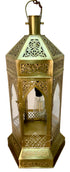 An ornate brass Moroccan lantern with intricate cutout patterns, clear glass panels, and a hanging loop at the top, shown against a plain white background.