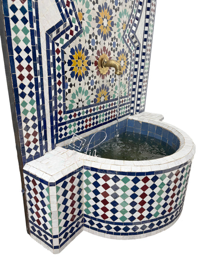 Mosaic-tiled corner bathtub with decorative patterns on a white background