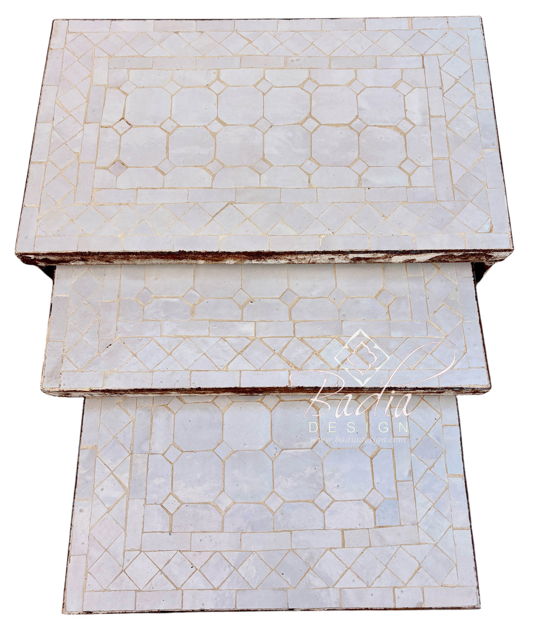 Three rectangular nesting tables stacked vertically, featuring a white mother-of-pearl inlay with a geometric pattern and gold-toned accents, set against a plain white background.