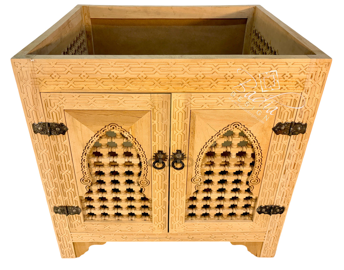 A light natural wood cabinet with intricate geometric carvings and two arched door panels featuring lattice cutouts, dark metal hinges, and ring pulls, shown on a plain white background.