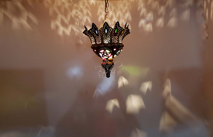 Decorative hanging lamp with intricate design against a blurred background