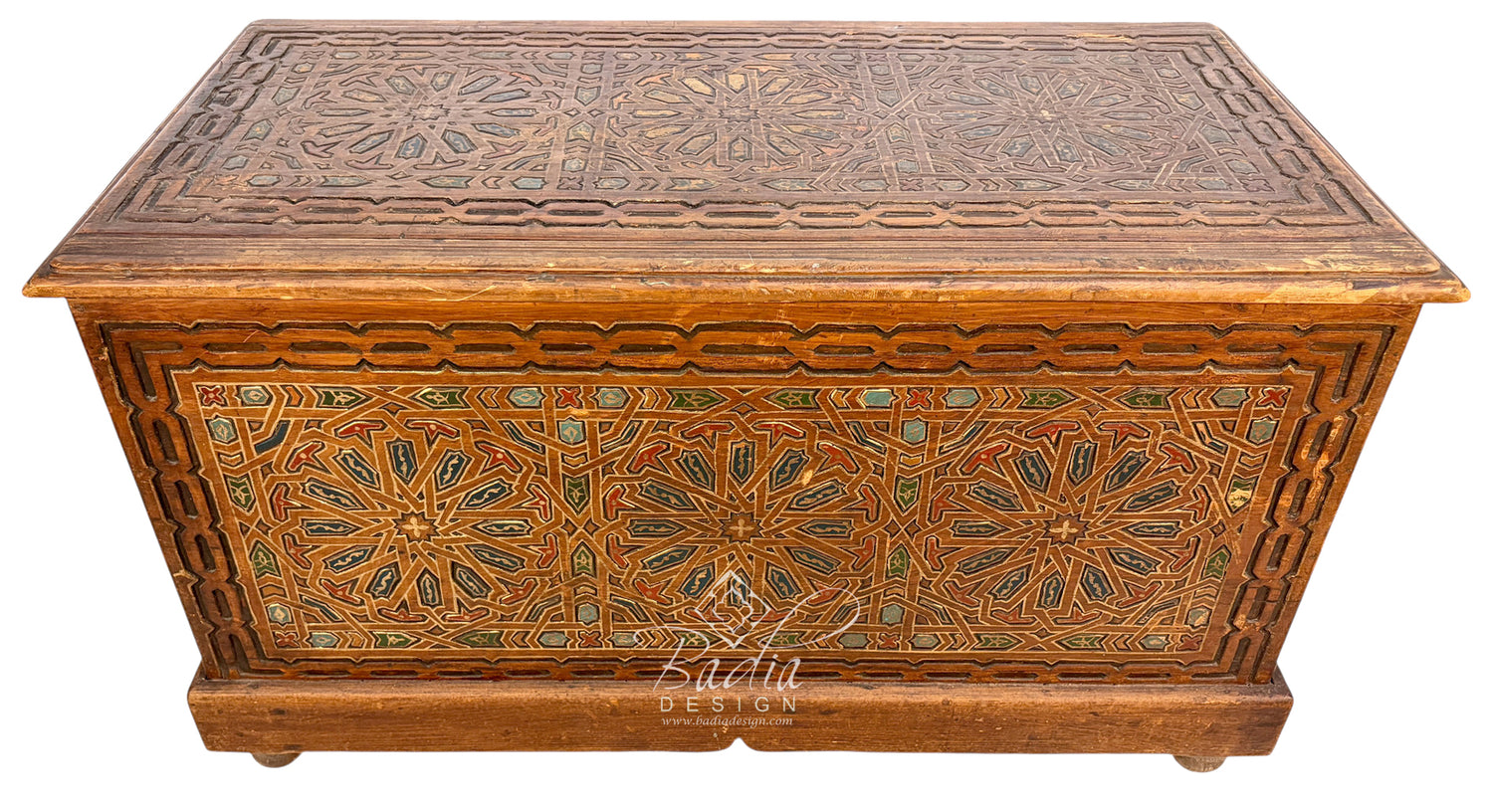 An ornate rectangular wooden storage chest or trunk with carved geometric and floral patterns, featuring a warm brown finish and decorative inlays, shown against a plain white background.